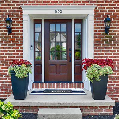 Brown, wooden front door of a residential home by Therma-Tru