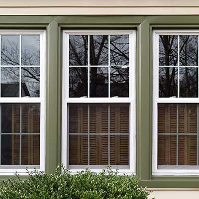 Close up of green framed windows on the outside of a home