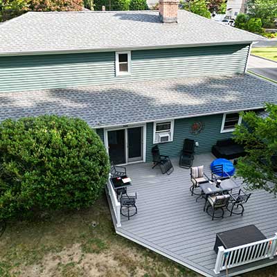 Back side of a residential home with a large deck close to the floor